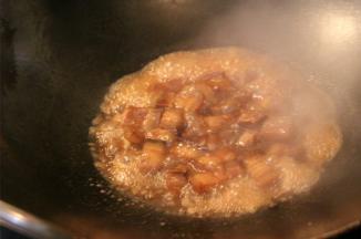 倒入生抽和糖色，翻炒均匀，加入适量的温水没过五花肉，大火烧开