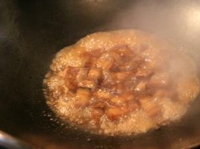 倒入生抽和糖色，翻炒均匀，加入适量的温水没过五花肉，大火烧开