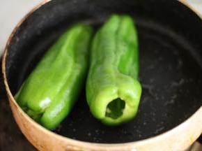 锅内放入少许的油，中火加热，油温三成热的时候放入青椒，转小火，用铲子按压青椒，不断地翻面，让青椒受热均匀，当青椒的表面都呈现出均匀的花纹就可以盛出了