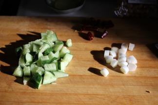 黄瓜切成丁，大葱切成段，准备好花椒粒和干辣椒