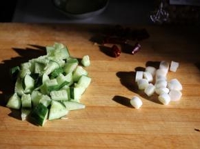 黄瓜切成丁，大葱切成段，准备好花椒粒和干辣椒