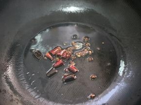 锅内留底油，放入花椒和干辣椒小火炒出香味，放入葱段