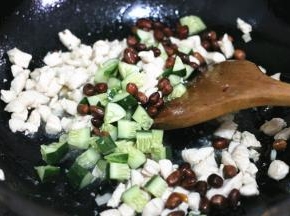 放入黄瓜和花生米，倒入调料汁翻炒均匀