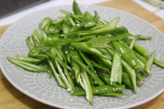 辣椒洗净之后斜刀切成段状，将多余的辣椒籽去掉，这样吃起来辣椒不会非常的辣，也不会影响整体的口感