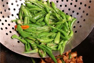 倒入切好的杭椒和姜蒜，大火爆炒，炒到辣椒的表皮微微泛白