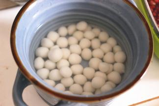 锅内重新倒水烧开，加少许的白糖或者冰糖，搅拌至融化，倒入煮好小圆子碗中