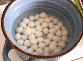 锅内重新倒水烧开，加少许的白糖或者冰糖，搅拌至融化，倒入煮好小圆子碗中