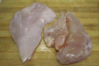 鸡胸肉洗净之后，从最厚的中间处横向片成两片，这样鸡排在腌制的过程中会更加入味
