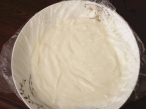 将适量的枫糖浆和酸奶混合均匀，平铺到带有油纸的盘子上，厚度为1-2厘米左右