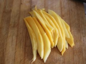 盛入碗中定型，倒扣在盘子上将芒果去皮切片，摆在糯米饭的旁边