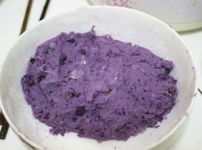 根据自己的口味往紫薯泥中放入适量的白糖，搅拌均匀，加入糯米粉，加适量的牛奶和成面团