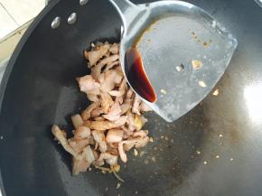 猪肉炒至颜色稍深的时候，放入耗油和酱油，继续翻炒