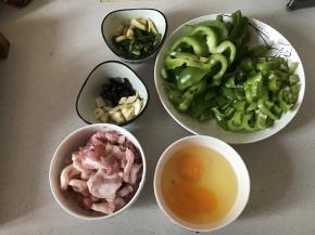 将五花肉洗净切片，青椒、杭椒、尖椒切丝，鸡蛋打在碗里，姜蒜包好切块和豆豉放在碗里，做好准备