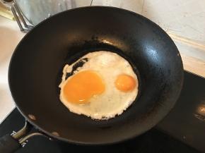 在锅里加入少许油，把鸡蛋下锅，煎熟，尽量不要破坏鸡蛋的形状，
