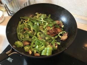 锅内加入青椒和尖椒继续翻炒