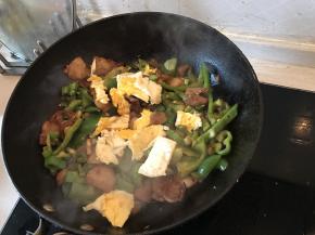 在锅内加入煎熟的鸡蛋块，大火翻炒几下，即可出锅