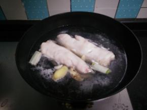 猪蹄冷水下锅，加入姜片、葱段、蒜块大火煮沸，撇去浮沫，中火煮15分钟