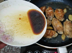两次翻面煎黄鸡翅之后，将之前剩下的腌汁倒入锅中，焖透鸡肉