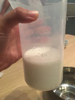 将步骤一中的吉利丁粉液倒入煮融的牛奶液中，搅拌均匀后过筛，倒回量杯