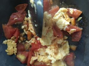 把划散的蛋块重新倒入锅中，将番茄酱汁和蛋块炒匀