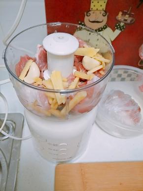 肉切块放入料理机，一同放入生姜和葱打成肉泥，由于家里没有葱了，所以我用蒜来代替。