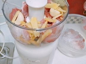 肉切块放入料理机，一同放入生姜和葱打成肉泥，由于家里没有葱了，所以我用蒜来代替。