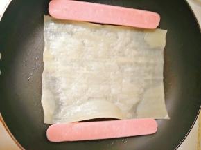 锅内倒少许油，放入冷面和肠，烤肠可以提前煎一下，放入冷面后，在冷面上刷些水。