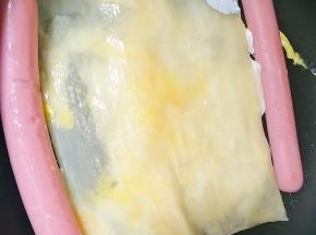 将鸡蛋摊开后，面皮翻转。