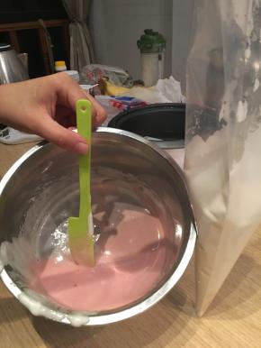 将步骤三的蛋清液分装入裱花袋，一份不加色素（多一点），一份加色素（少一点）。