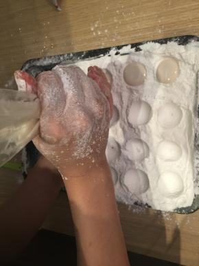 在圆坑里挤入白色蛋清液，稍稍晾凉后，再用加了色素的蛋清液在上面画猫爪。