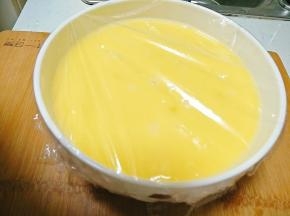 豆腐切好后放入蛋液中，盖上保鲜膜，并用叉子在保鲜膜上插几个洞。