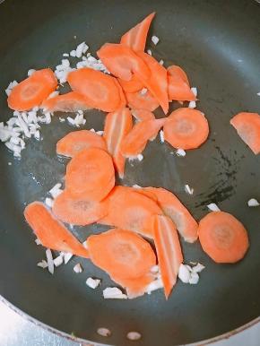 煮热锅冷油、爆香后，放入胡萝卜片翻炒。