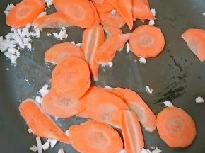 煮热锅冷油、爆香后，放入胡萝卜片翻炒。