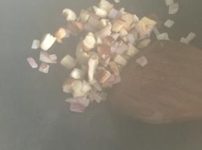 炒锅开火热油，先倒入洋葱、香菇丁划几下，然后加入料酒。