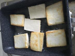 将豆腐一块块放入平底锅煎，分几次煎。