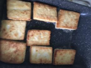 当豆腐有一面变成金黄色后，翻面。