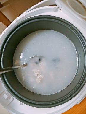 鸡肉丁变色后，米连同泡制的水一同倒入电饭煲内，放入姜丝，火腿丁和一半皮蛋，搅拌均匀开煮。