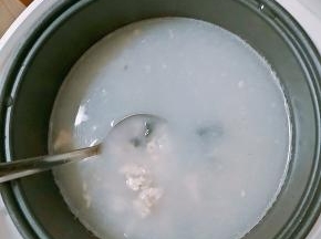 鸡肉丁变色后，米连同泡制的水一同倒入电饭煲内，放入姜丝，火腿丁和一半皮蛋，搅拌均匀开煮。