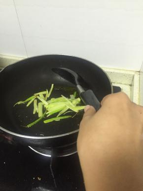 加入食用油，将葱段放入煎