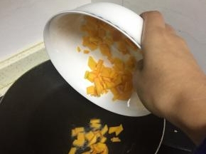 准备好南瓜两块，去皮去瓤，切成丁，锅中加入适量的橄榄油，翻炒2-3分钟