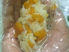拿出炒好的南瓜饭，捏成长条团子