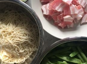 准备材料，五花肉切片，豆角斜切成段，湿面条切成约15厘米长的短面条，这样最后和菜混合的时候就不会因为面条太长而打结，更容易搅拌均匀。葱姜蒜切好备用。