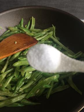 起锅热油将剩下一把葱姜蒜爆香，下入豆角翻炒两分钟后加比平时炒菜略多的盐调味。
