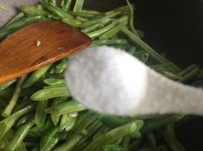 起锅热油将剩下一把葱姜蒜爆香，下入豆角翻炒两分钟后加比平时炒菜略多的盐调味。