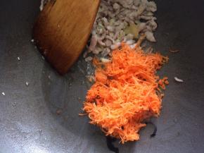 将肉丝拨到一边，下入胡萝卜丝炒软后，下木耳翻炒均匀。