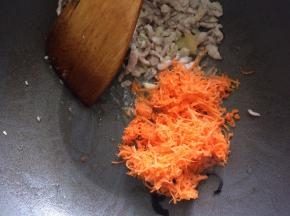 将肉丝拨到一边，下入胡萝卜丝炒软后，下木耳翻炒均匀。