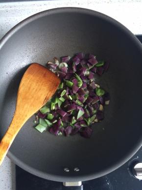 起锅爆香葱姜蒜，下入紫扁豆翻炒均匀。