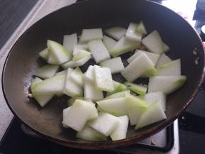 锅内放油爆香蒜末，下入冬瓜翻炒。