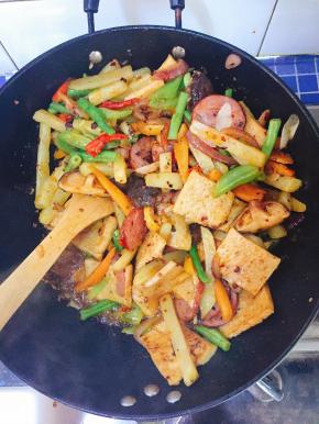 倒入以上已经准备好的各种食材翻炒，使均匀入味，并加入适量食盐调味。