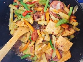 倒入以上已经准备好的各种食材翻炒，使均匀入味，并加入适量食盐调味。